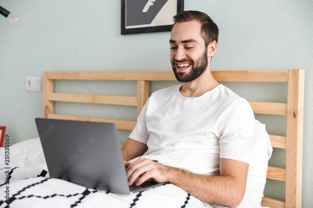 Handsome young man laying in bed Handsome young man laying in bed