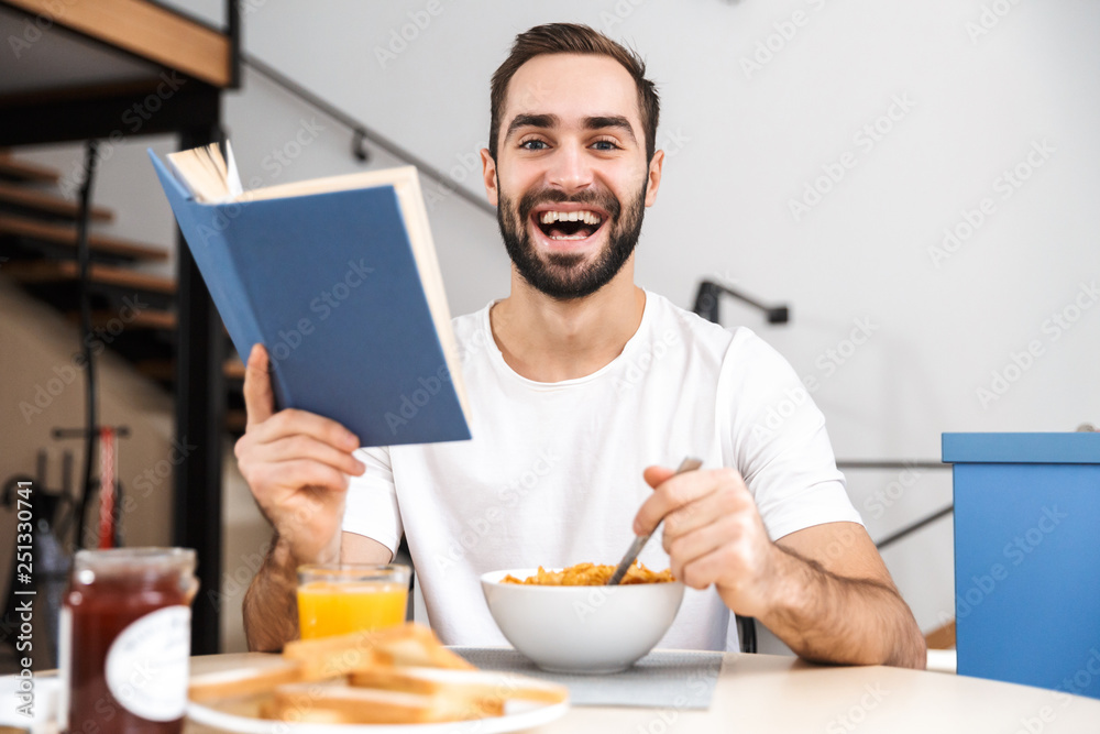Handsome young man having breakfast