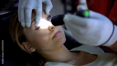 Konstfotografi Doctor shining light into patient eye, testing pupil reflexes, first aid closeup