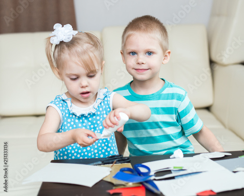 cute, smiling children, boy and girl, brother and sister 3-5 years old, scissors and cut out applications