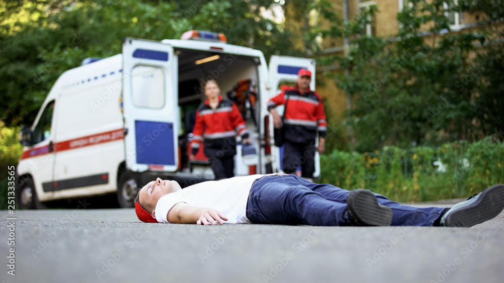 Unconscious man lying on road, paramedics running to victim of car ...