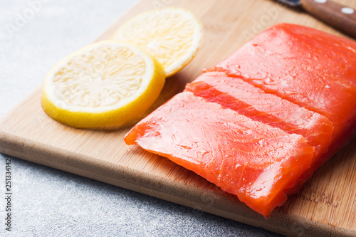 Fresh salmon fillet with lemon on a cutting Board.
