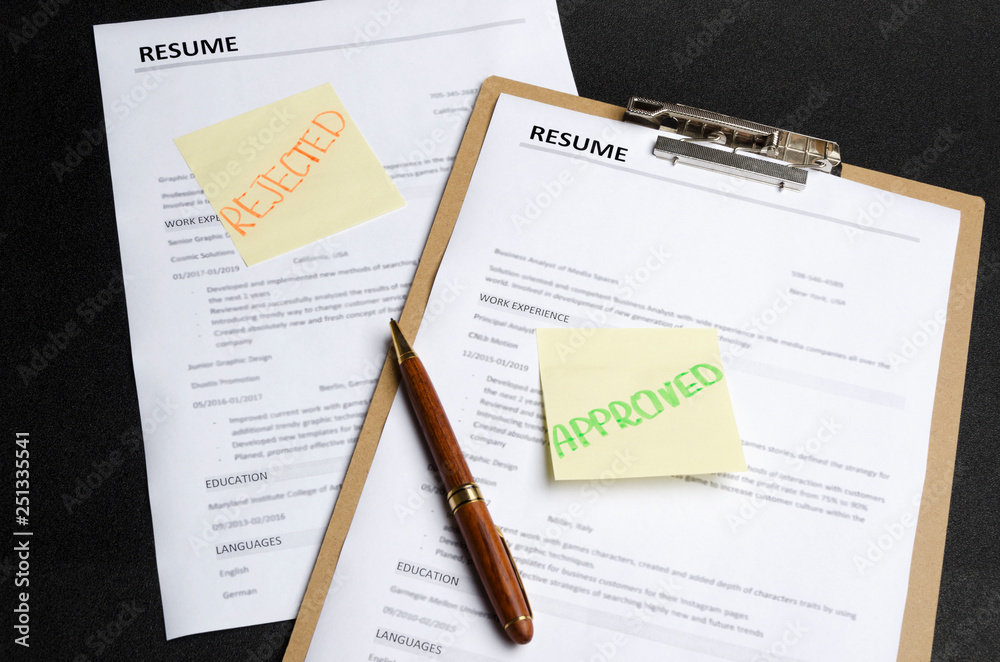 Two resume templates and sticks on it, black background. HR made decision and approved one candidate and rejected to another.Process of reviewing resume applications Two resume templates and sticks on it, black background. HR made decision and approved one candidate and rejected to another.Process of reviewing resume applications