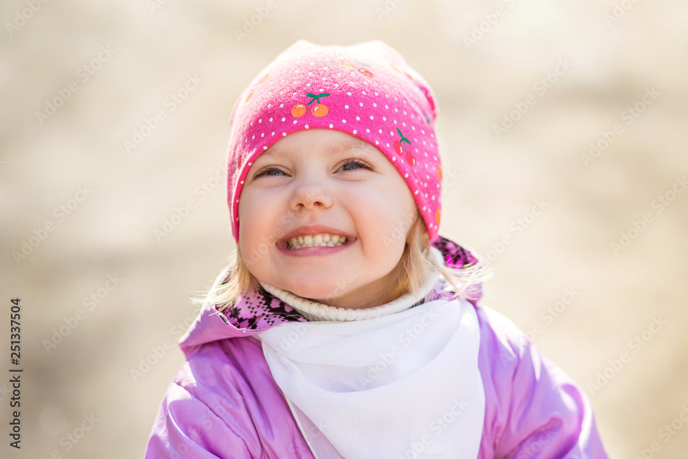 little girl in a pink hat in the early spring walks on the street little girl in a pink hat in the early spring walks on the street