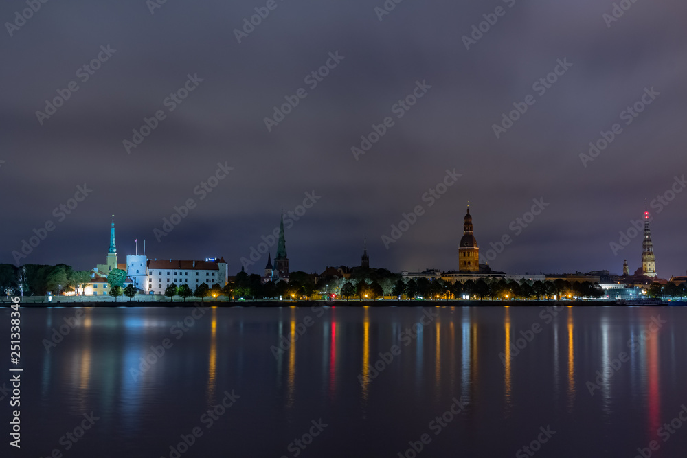 Panoramic night view on old Riga the capital of Latvia city from left bank of Daugava river. Its unique with a medieval and Gothic architecture.