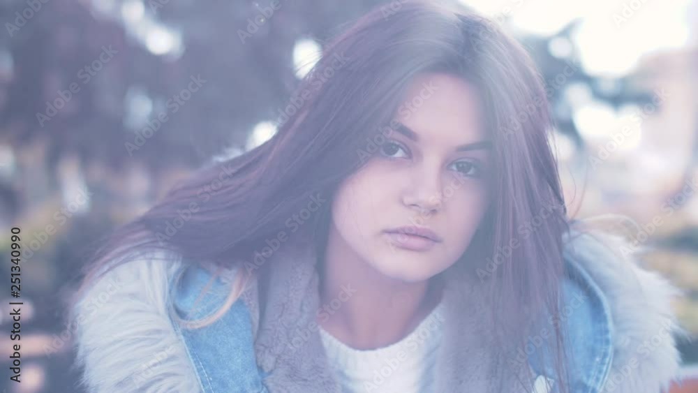 Portrait of young girl close up with green trees on background. Nice women with blowing her hair in slow motion and lens flares. Portrait of young girl close up with green trees on background. Nice women with blowing her hair in slow motion and lens flares.