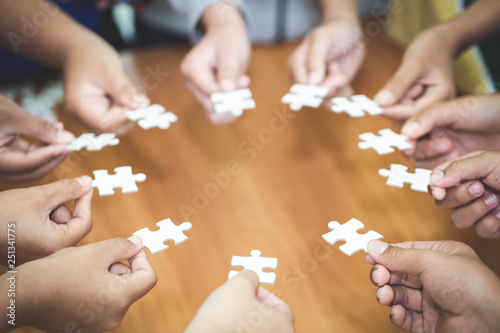 Many persons holding pieces of jigsaw puzzle Teamwork concept  Business connection Success and strategy concept Business accounting