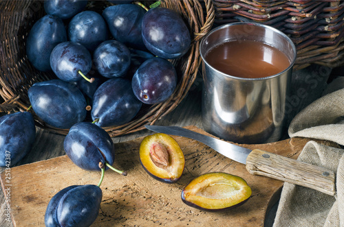 Ripe plums and plum juice in a mug
