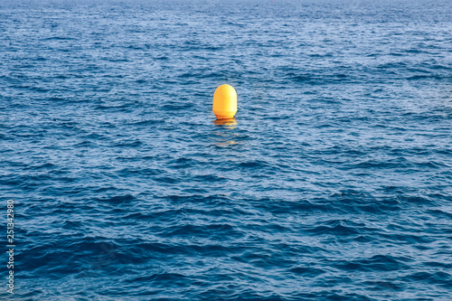 Yellow buoy on background of blue sea, concept loneliness © Parilov