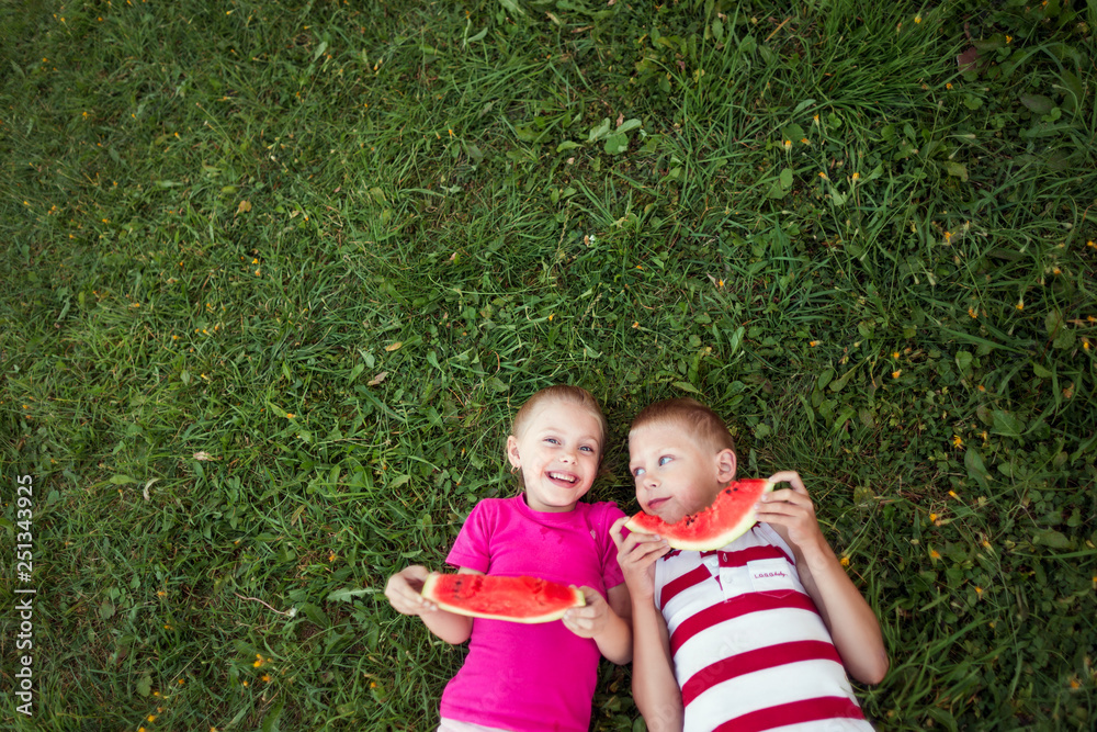 cute happy children boy and girl 6-7 years old eating watermelon outdoors cute happy children boy and girl 6-7 years old eating watermelon outdoors