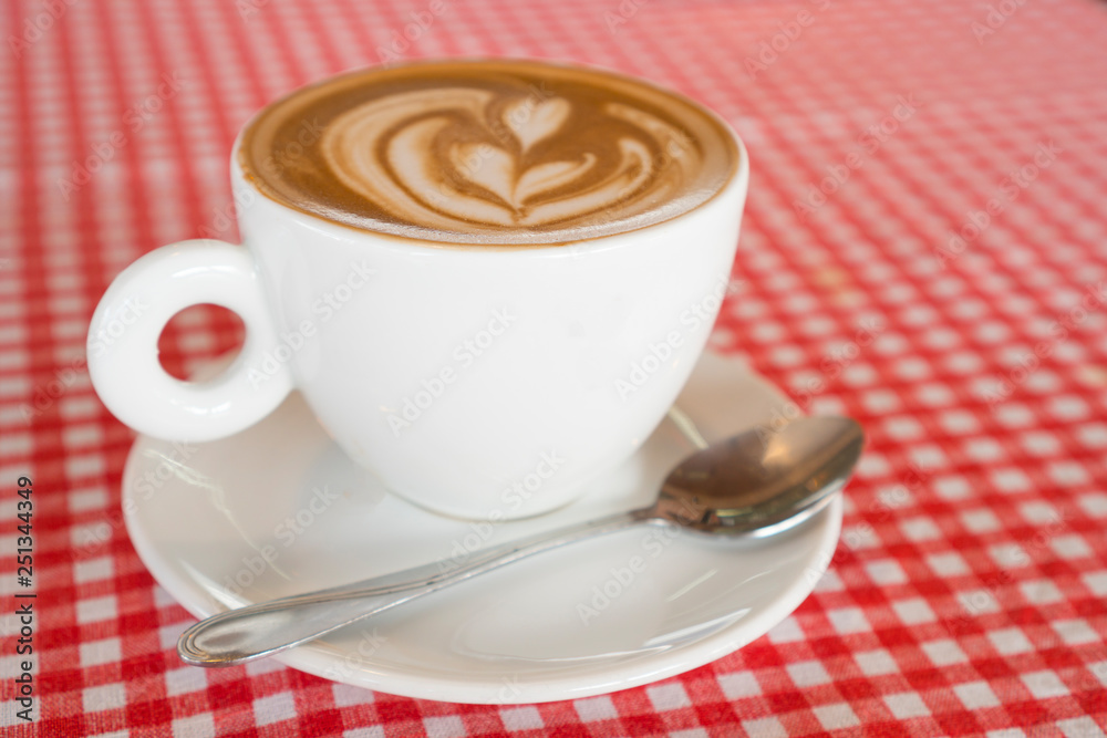Coffee cup placed on red and white patterned fabric Coffee cup placed on red and white patterned fabric