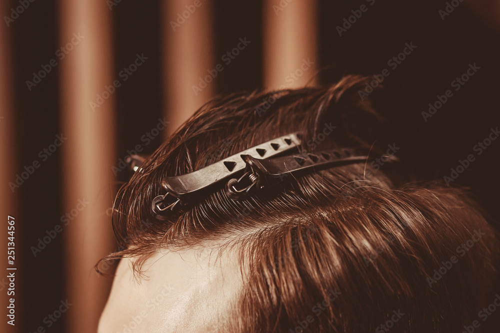 Fototapeta premium Close up. Styling client haircut with hair clips in Barber shop