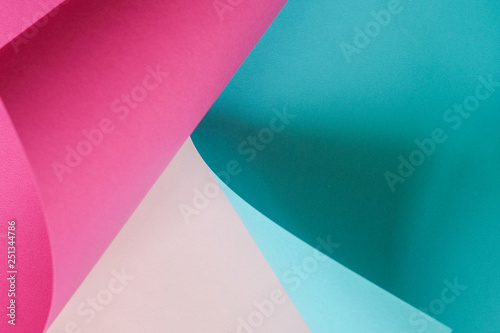 A sheet of paper blue and pink rolled into a tube on a light background.