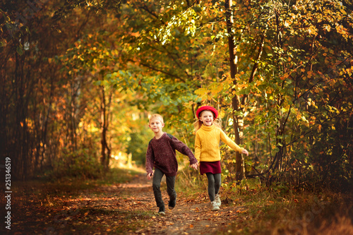 children run in the park in autumn