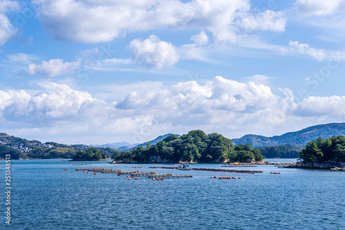 Many small islands over the blue ocean in sunny day, famous Kujukushima(99 islands) pearl sea resort islet in Sasebo Saikai National Park, Nagasaki, Kyushu, Japan. photo