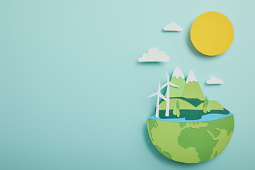 top view of paper cut planet with renewable energy sources on turquoise background, earth day concept