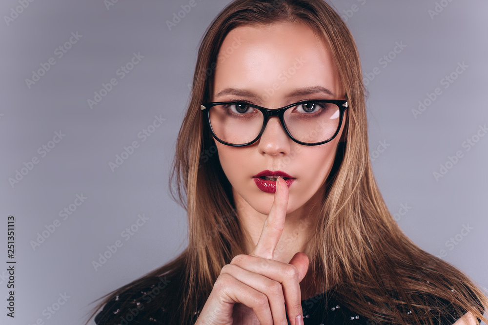 Portrait of young smart beauty blondie girl student posing in studio in fashionable glasses on grey background. Beauty, education, knowledge concept Portrait of young smart beauty blondie girl student posing in studio in fashionable glasses on grey background. Beauty, education, knowledge concept