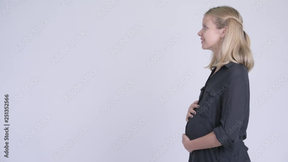 Profile view of young happy pregnant businesswoman smiling Profile view of young happy pregnant businesswoman smiling