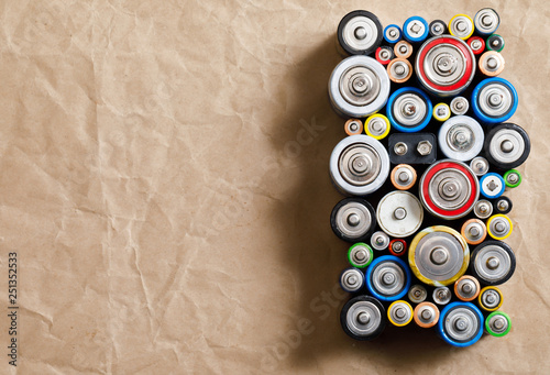 Used Alkaline batteries on recycled paper toxic waste recycling and ecology issues concept background