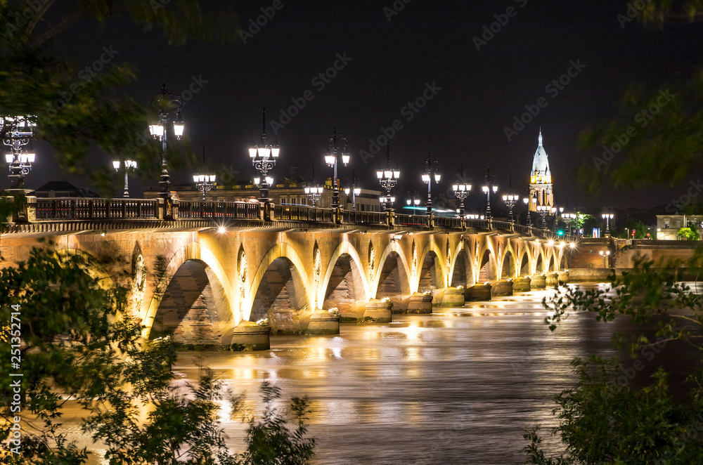 Night view of The Pont de Pierre, bridge over the Garonne river in Bordeaux city, France