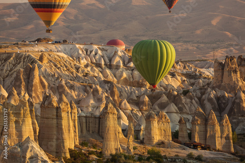 Beautiful landscape of Cappadocia valley with hot air balloons in background at sunrise