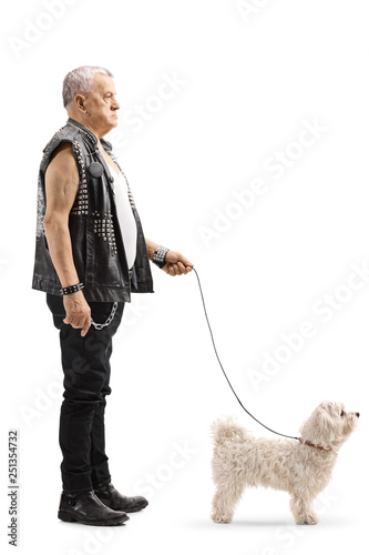 Mature punker standing with a little white dog