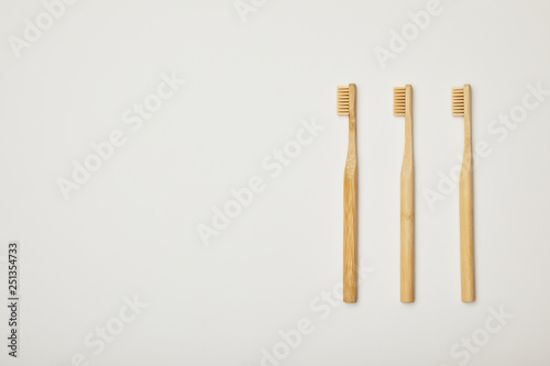 top view of bamboo brown toothbrushes on white background