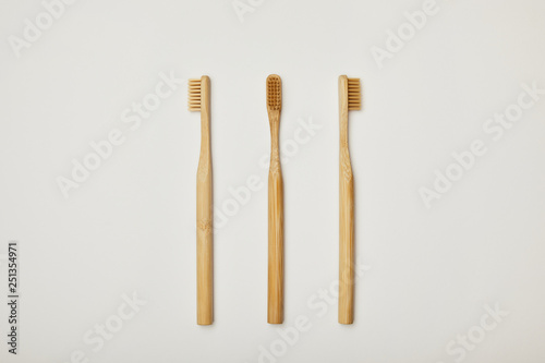top view of bamboo toothbrushes on white background