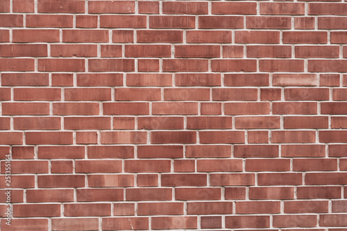 Background from a wall with red bricks of different shades and jointing