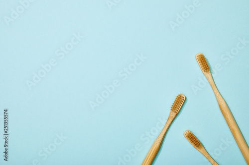 top view of bamboo toothbrushes on blue background