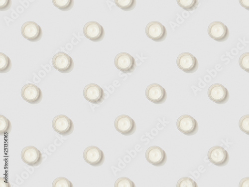 cosmetic cream in containers on grey background, seamless background pattern