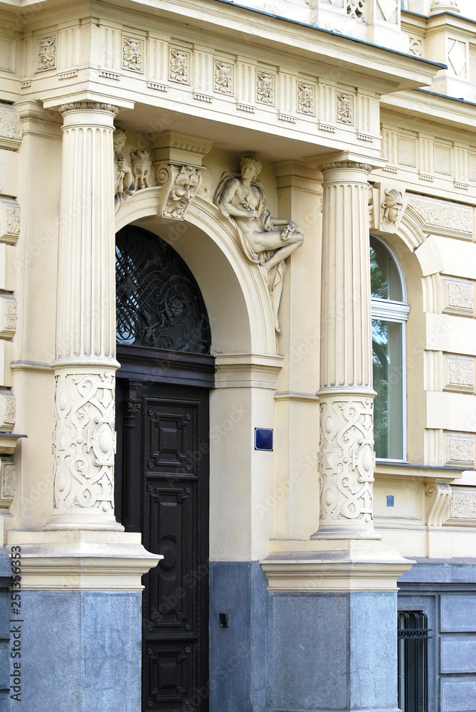 Decoration of the entrance to the building with architectural elements depicting the figures of people, Spring, Prague, Czech Republic.