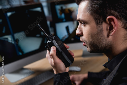 selective focus of guard holding walkie-talkie at workspace photo