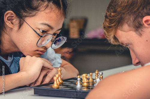 teenagers playing chess board together