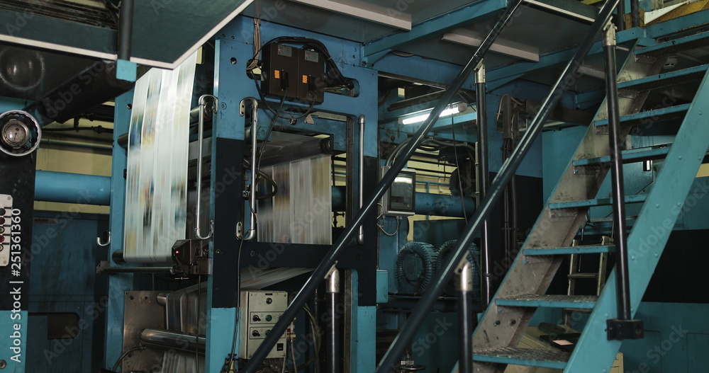Print plant factory. Newspaper printing at a plant. Newspaper printed on a printing house machine
