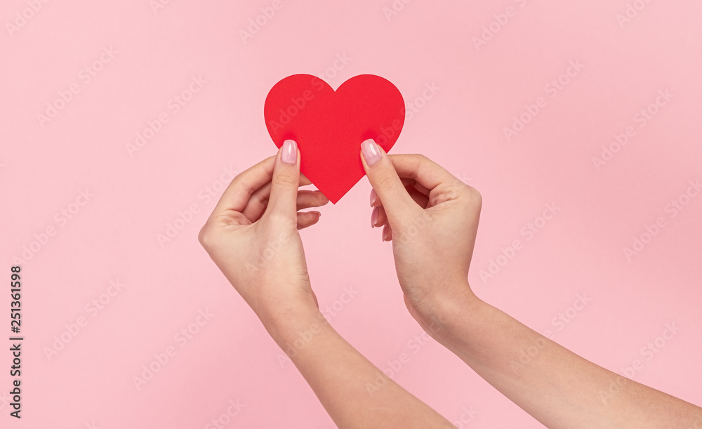 Woman showing red heart on pink background Woman showing red heart on pink background