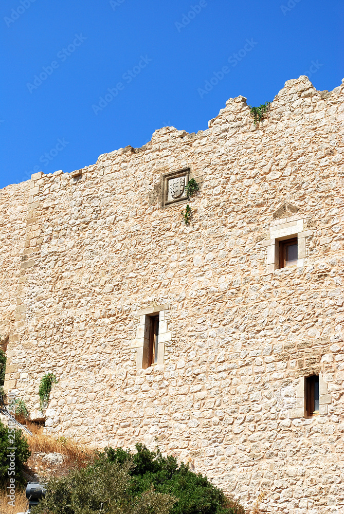 Fototapeta premium Close-up of stone wall with battlements of the ruins of Kritinia castle, Kritinia village, Rhodes island, Greece