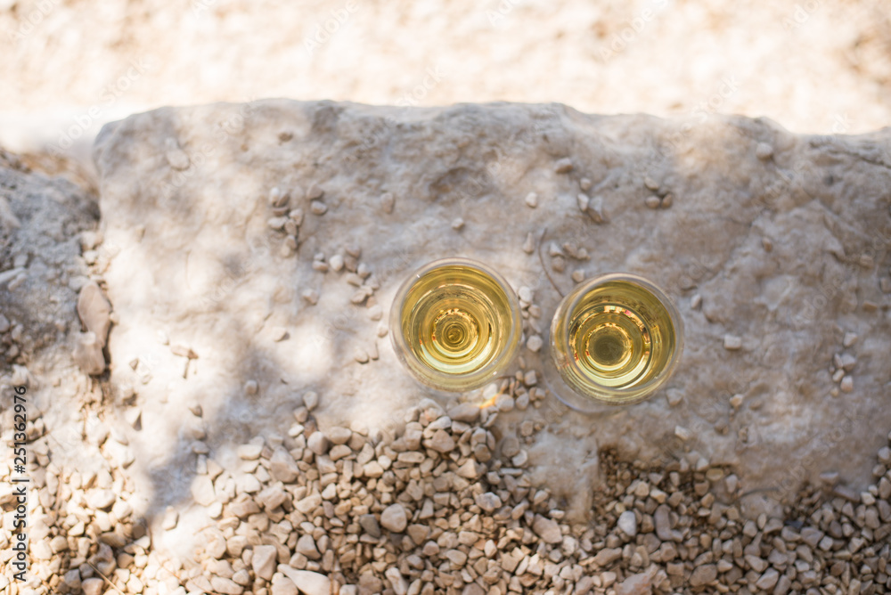 Two glasses of white wine at pebble beach Two glasses of white wine at pebble beach