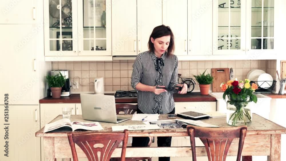 Young interior designer working on project by table in the kitchen Young interior designer working on project by table in the kitchen