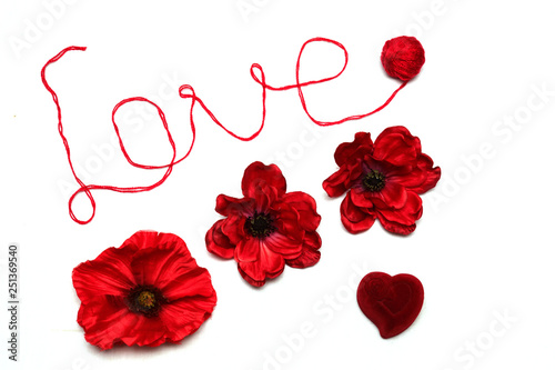 The word love is written in red thread on a white background. Red flowers and red box-heart on white background