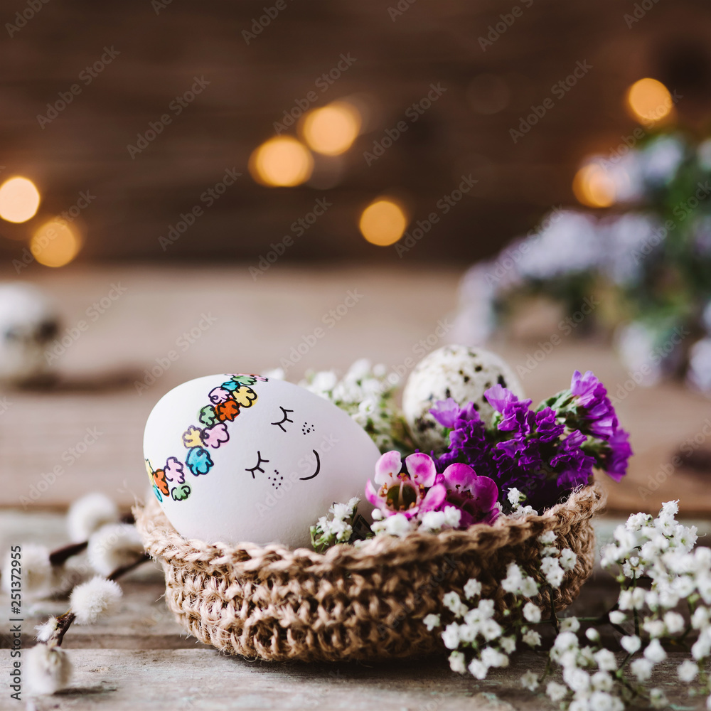 Knuddeliges Osterei im Osternest mit Blumen dekoriert Knuddeliges Osterei im Osternest mit Blumen dekoriert