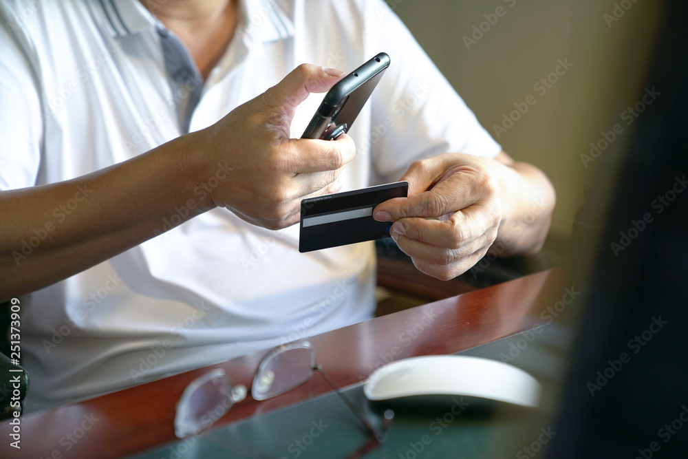 Online payment : Man holding a smart phone and credit card ready to make a purchase