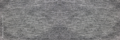 Gray fabric texture background of faded grey colored sweater. Cloth surface & material design for empty backdrop, modern fashion clothes pattern. Blank wide canvas and copy space template