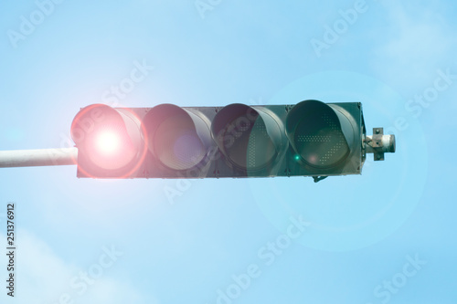 Expensive traffic lights with sparkling lights of red lights under blue sky.