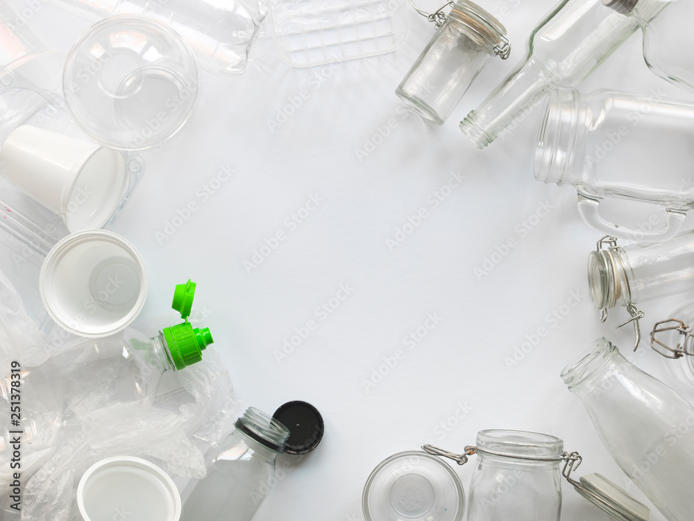 many different empty glass and plastic bottles lying on a white ...