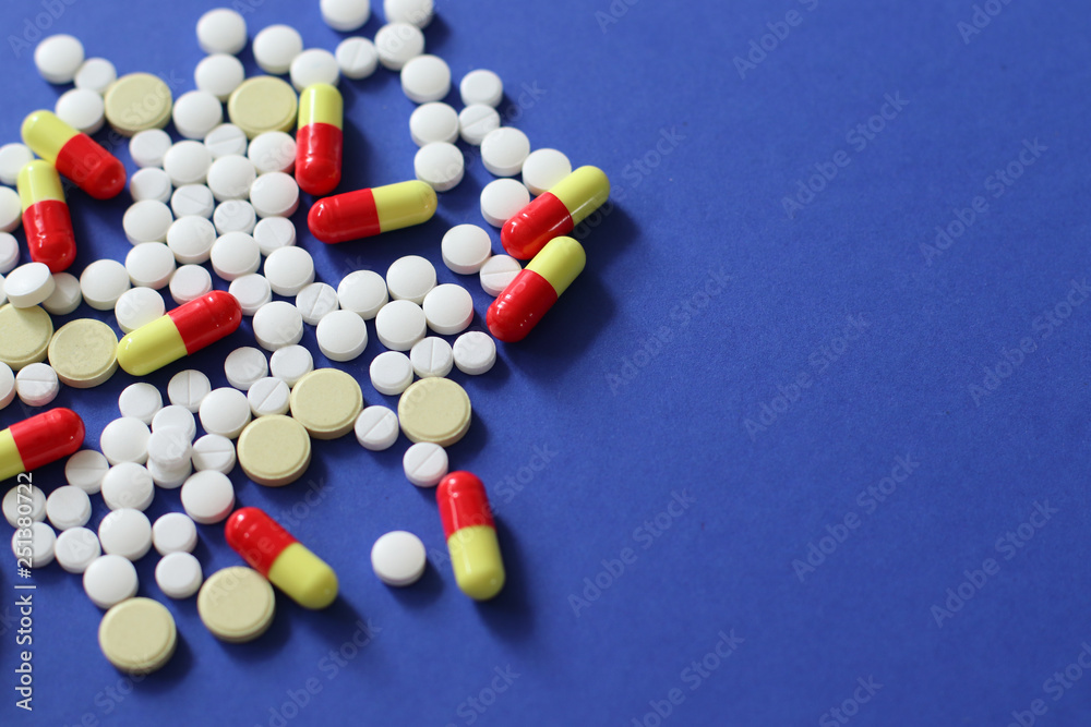 Heap of various pills isolated on blue background. Heap of various pills isolated on blue background.