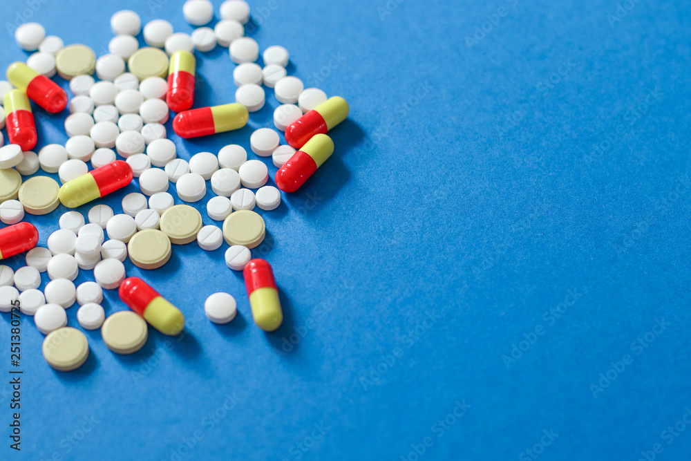 Heap of various pills isolated on blue background. Heap of various pills isolated on blue background.
