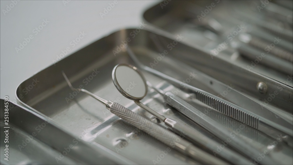 Steel dental instruments, mirror, on a blue background. Dental instruments. Steel dental instruments, mirror, on a blue background. Dental instruments.