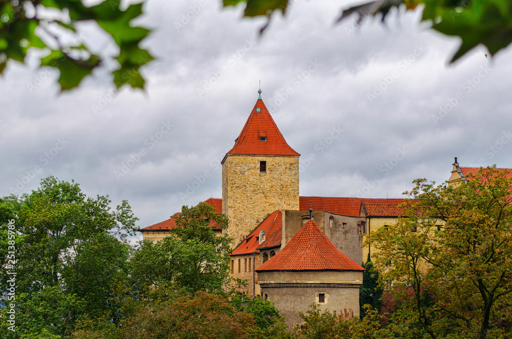 Red towers and wall of famous Hradcany castle. Prague, Czech Republic. Gloomy autumn weather