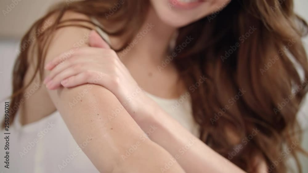 Woman skin care. Close up of female hand applying body cream on elbow at morning